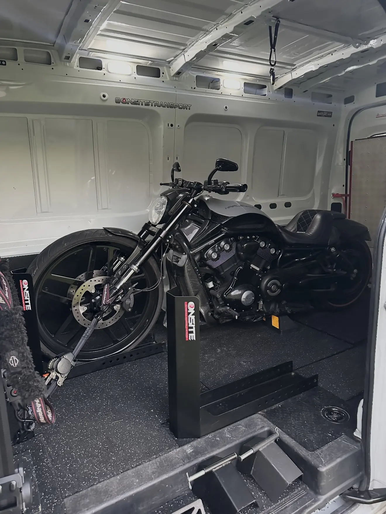 Black V-Rod style motorcycle secured inside the Onsite transport van