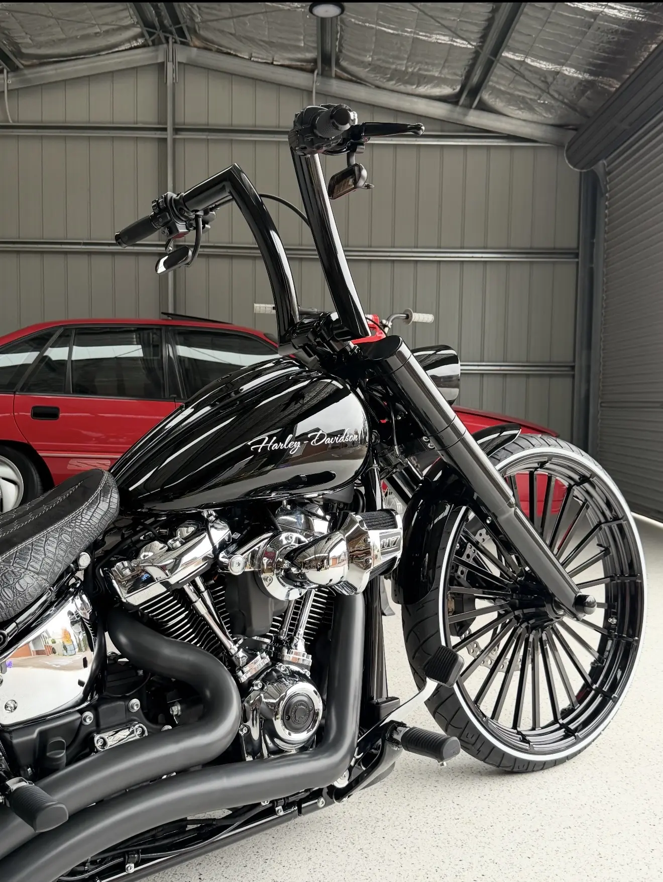 Black custom Harley-Davidson shown from the front side in the workshop