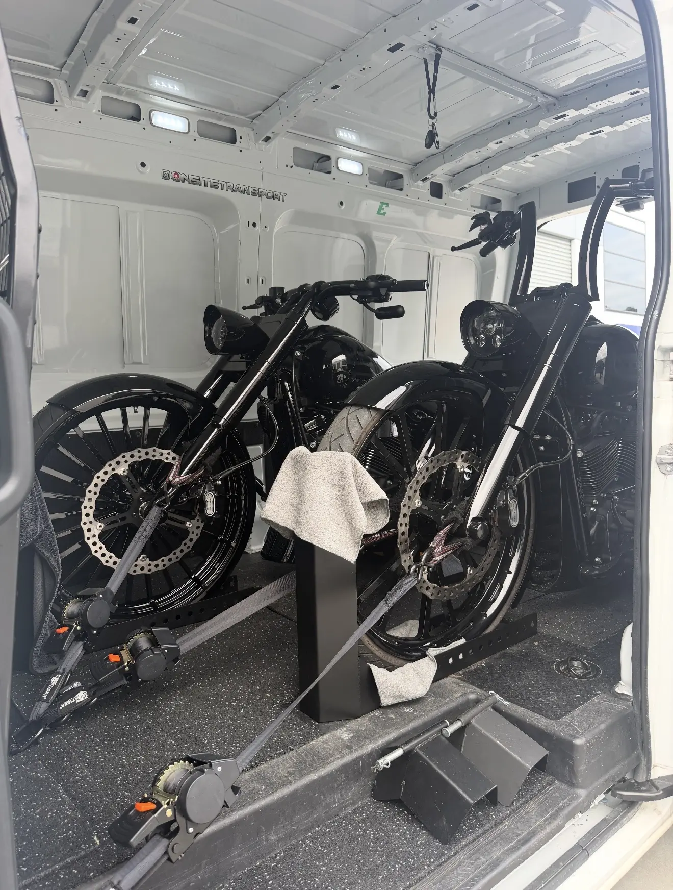 Black custom motorcycle loaded into the Onsite transport van