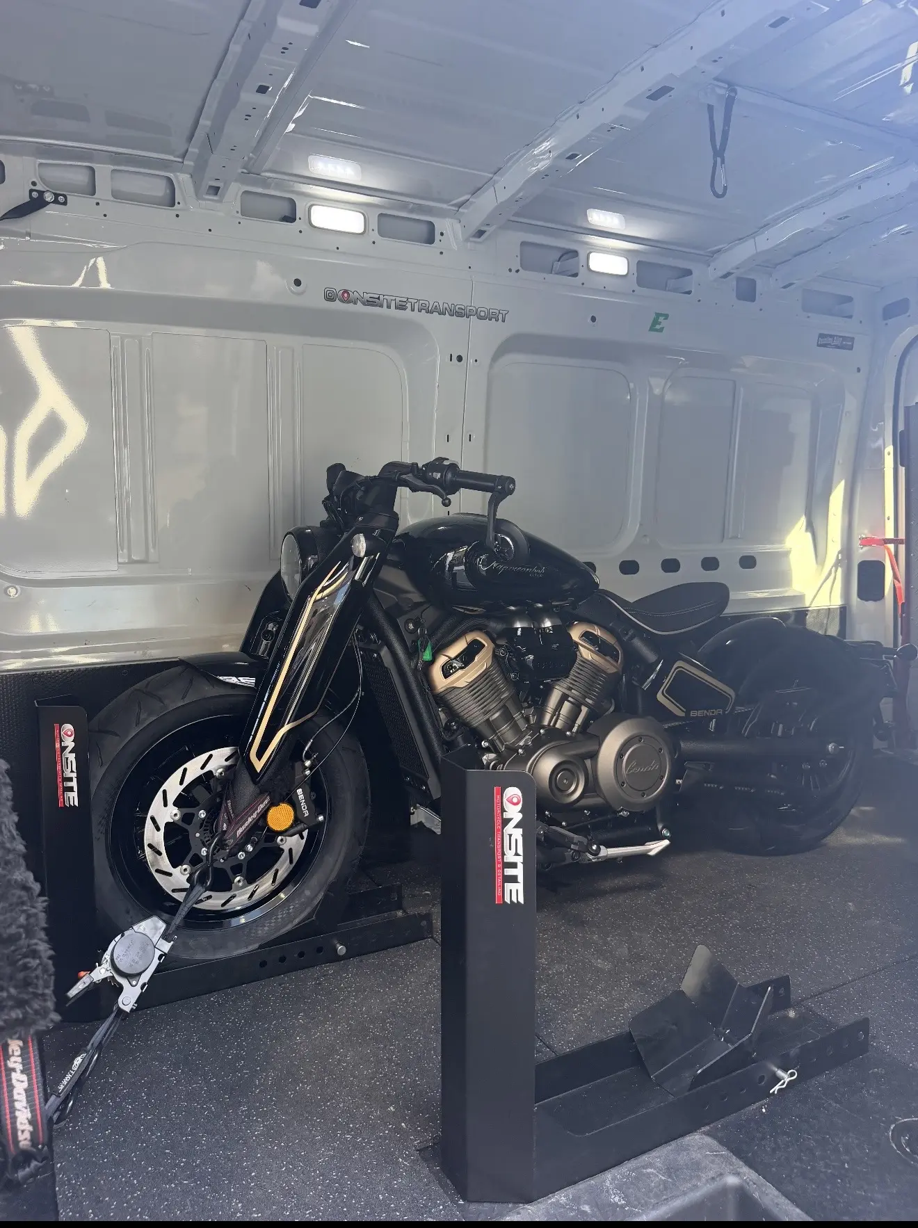 Black touring motorcycle secured for enclosed transport