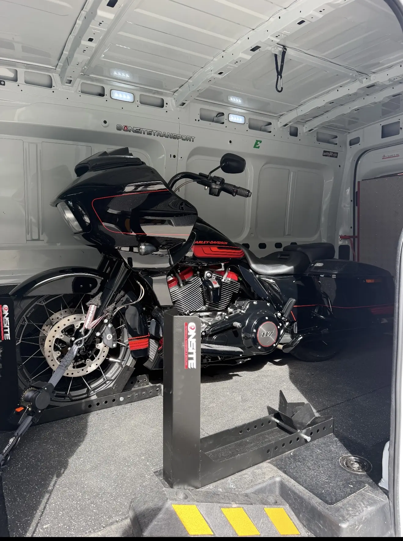 Black and red touring motorcycle loaded into the Onsite van