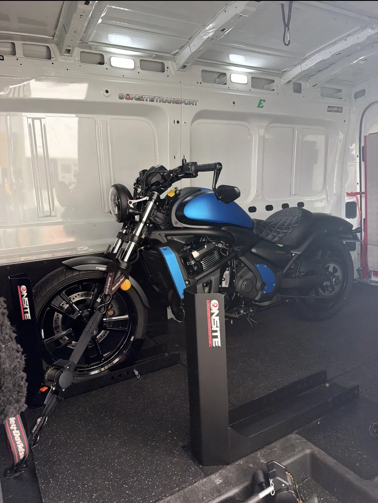 Blue custom motorcycle secured inside the Onsite transport van