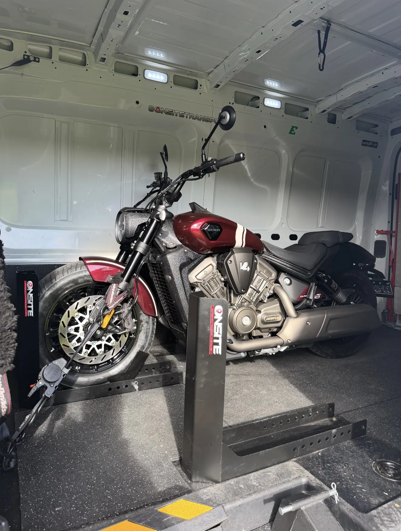 Red custom motorcycle loaded into the enclosed transport van