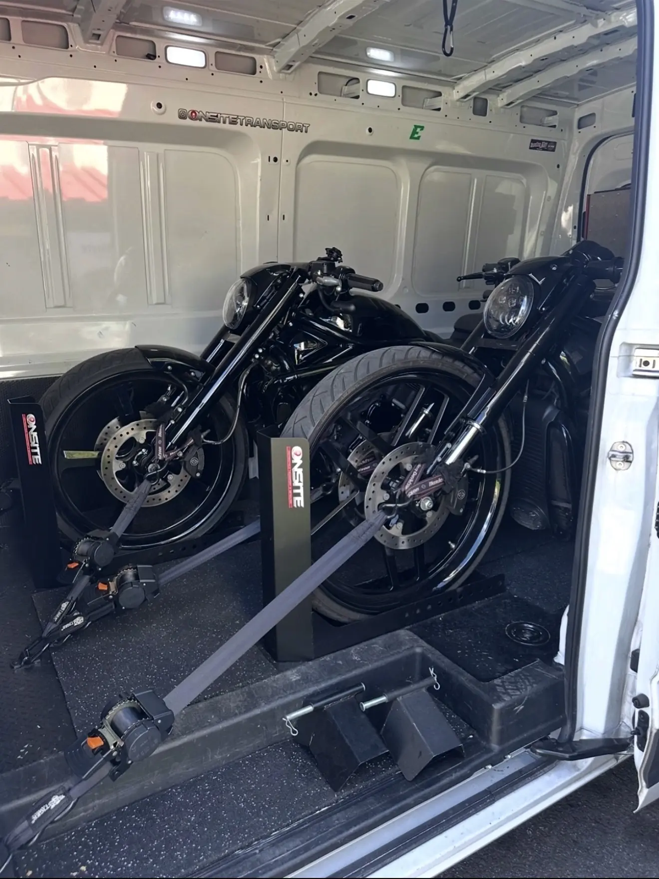 Two black custom motorcycles secured together for transport