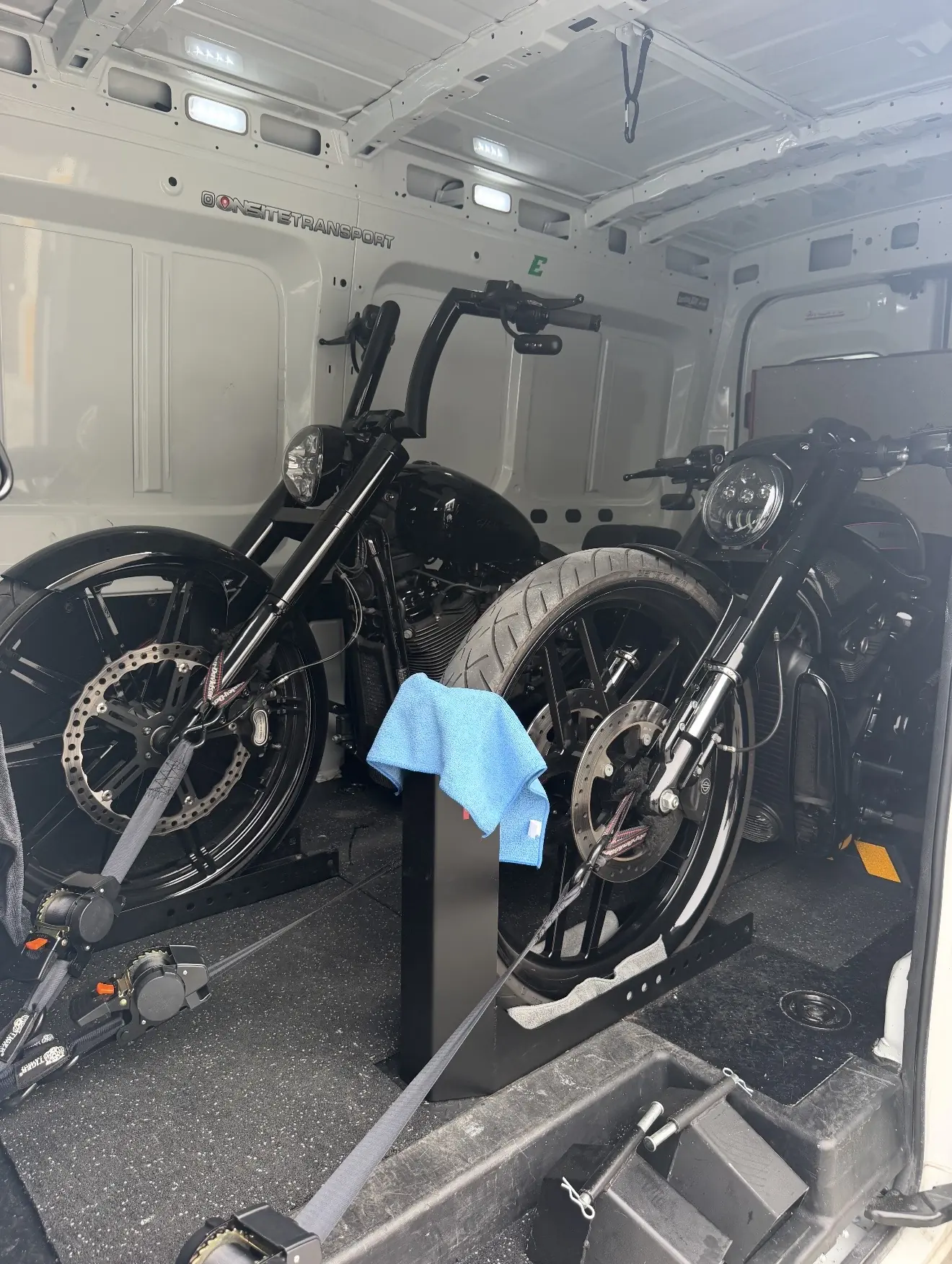 Pair of black custom motorcycles loaded for careful transport